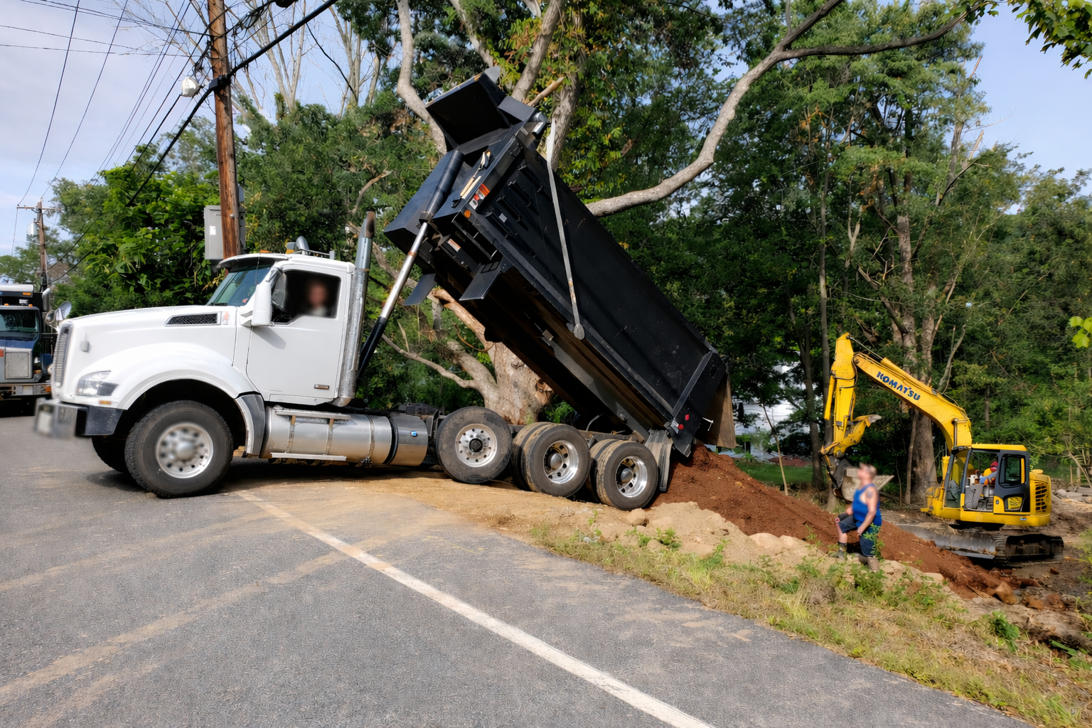 Dump truck unloading fill dirt for site work by GradeCraft Excavation in Warren County NJ