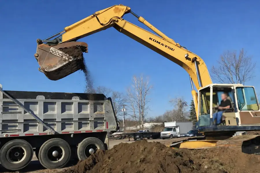 Excavator loading dump truck for dirt hauling in Warren County NJ by GradeCraft Excavation